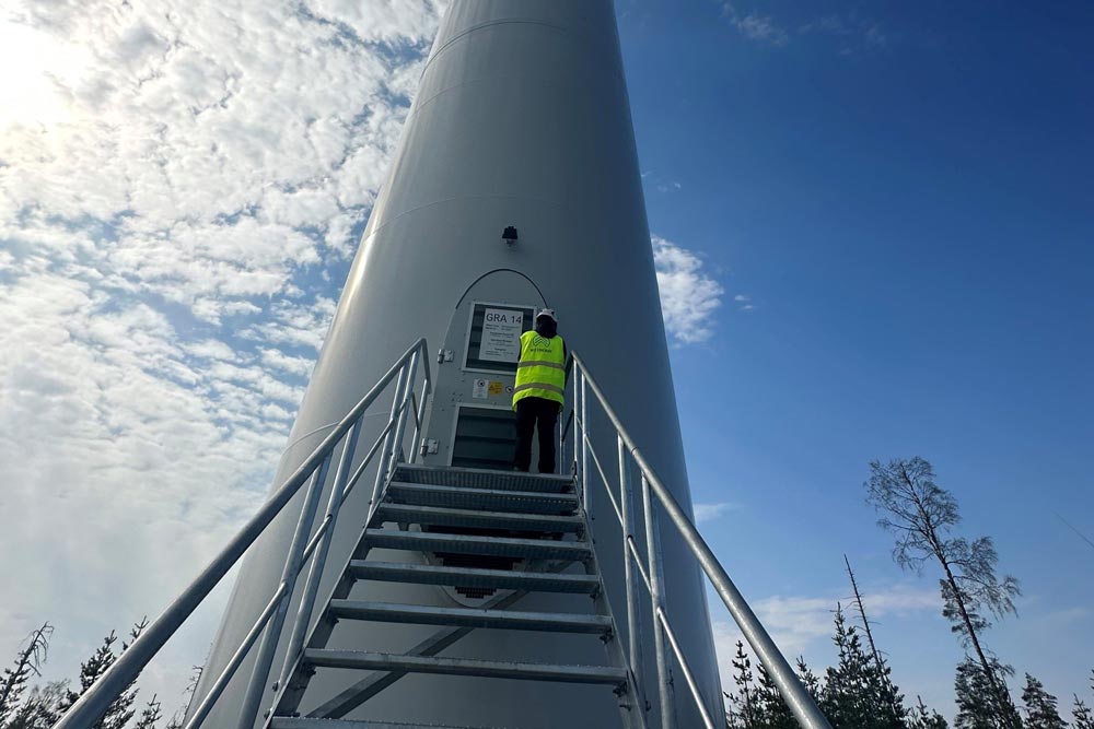 colleague at W3 Energy at a wind mill
